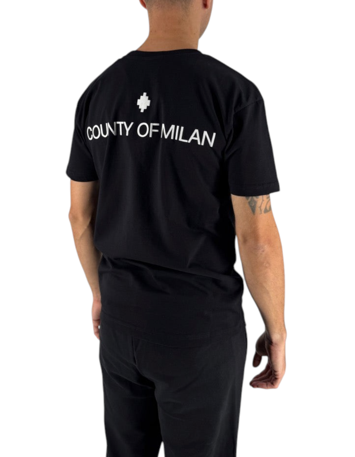 Modello di spalle indossa una t-shirt nera in cotone Marcelo Burlon County Of Milan con logo bianco da DevidLabel
