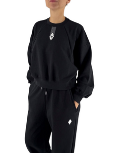 Modella indossa felpa crop nera Marcelo Burlon - County Of Milan con logo iconico, stile streetwear DevidLabel