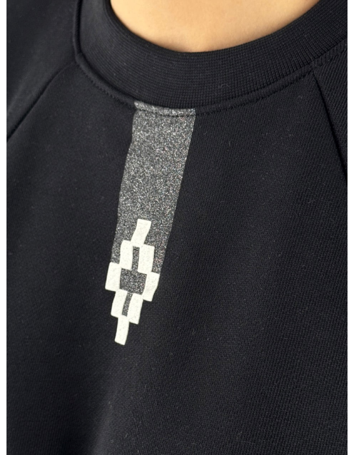 Dettaglio del logo grafico bianco su felpa crop nera Marcelo Burlon - County Of Milan disponibile su DevidLabel