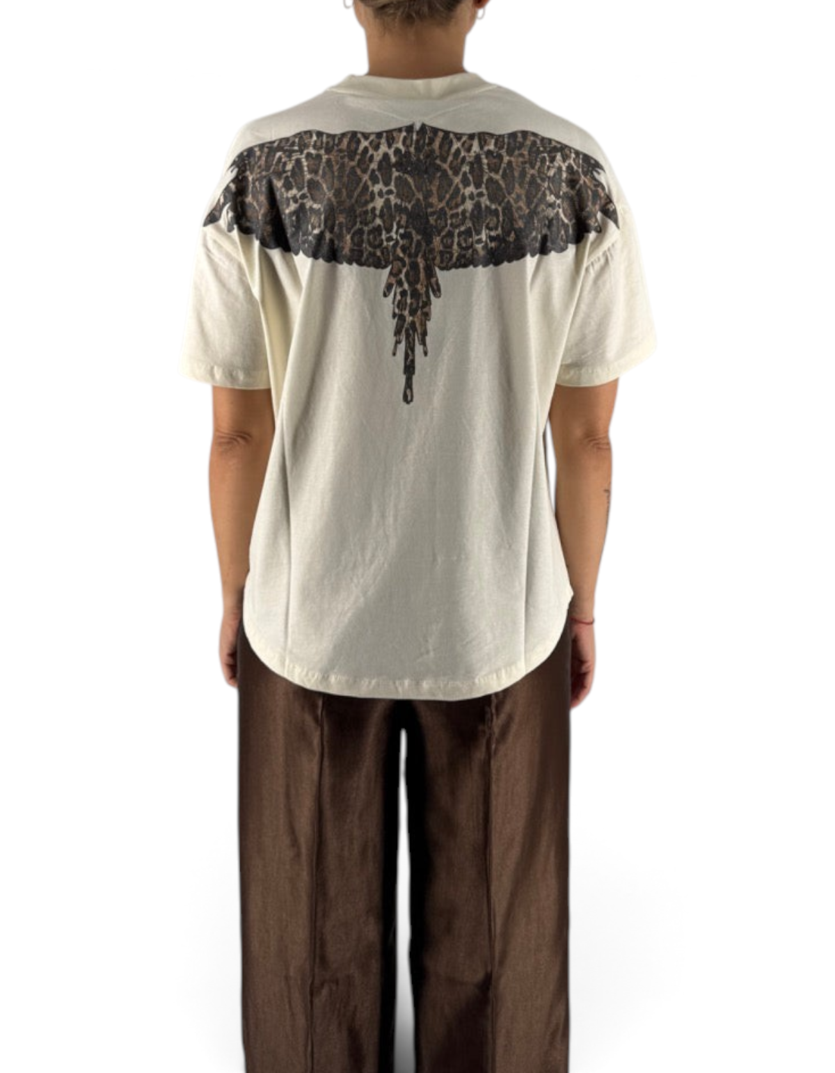Modella di spalle indossa maglia DevidLabel in jersey color latte con stampa grafica ali leopardate sul retro