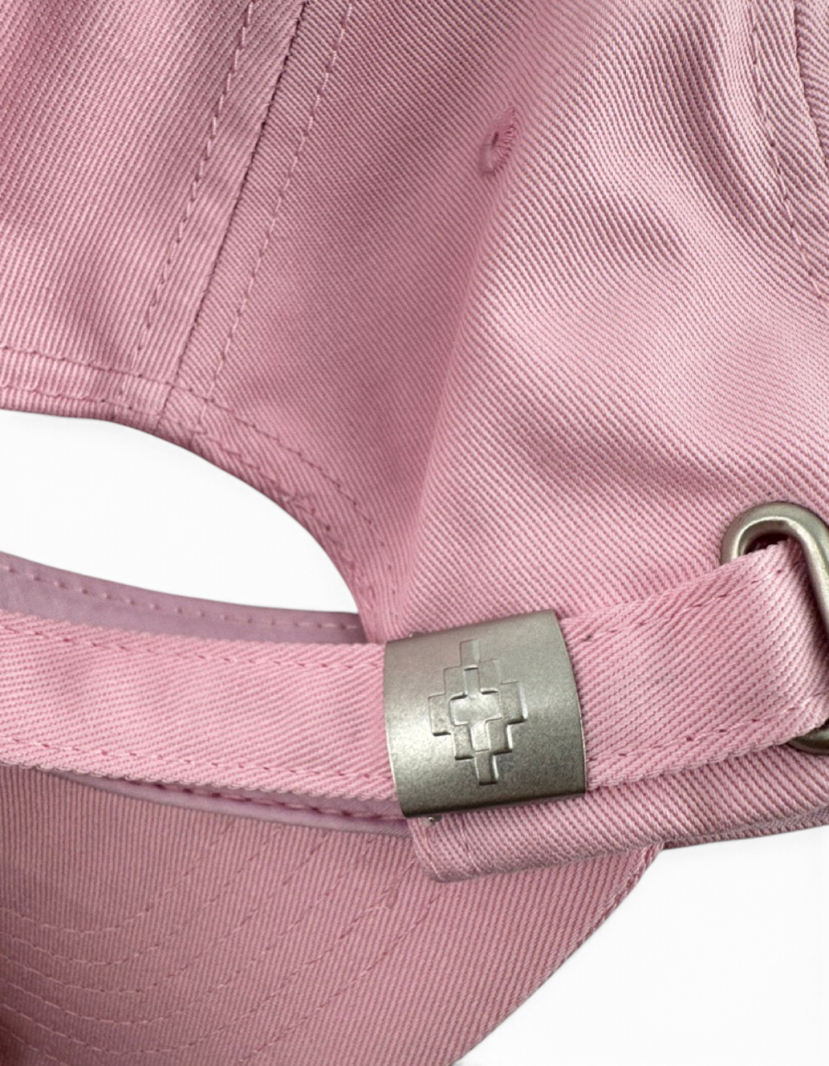 Dettaglio della fibbia metallica con logo sul retro del cappellino baseball rosa DevidLabel in cotone