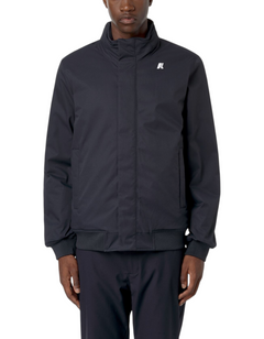Modello indossa giacca K-Way Amaury Twill Marmotta blu scuro con colletto alto e logo discreto, stile urbano invernale