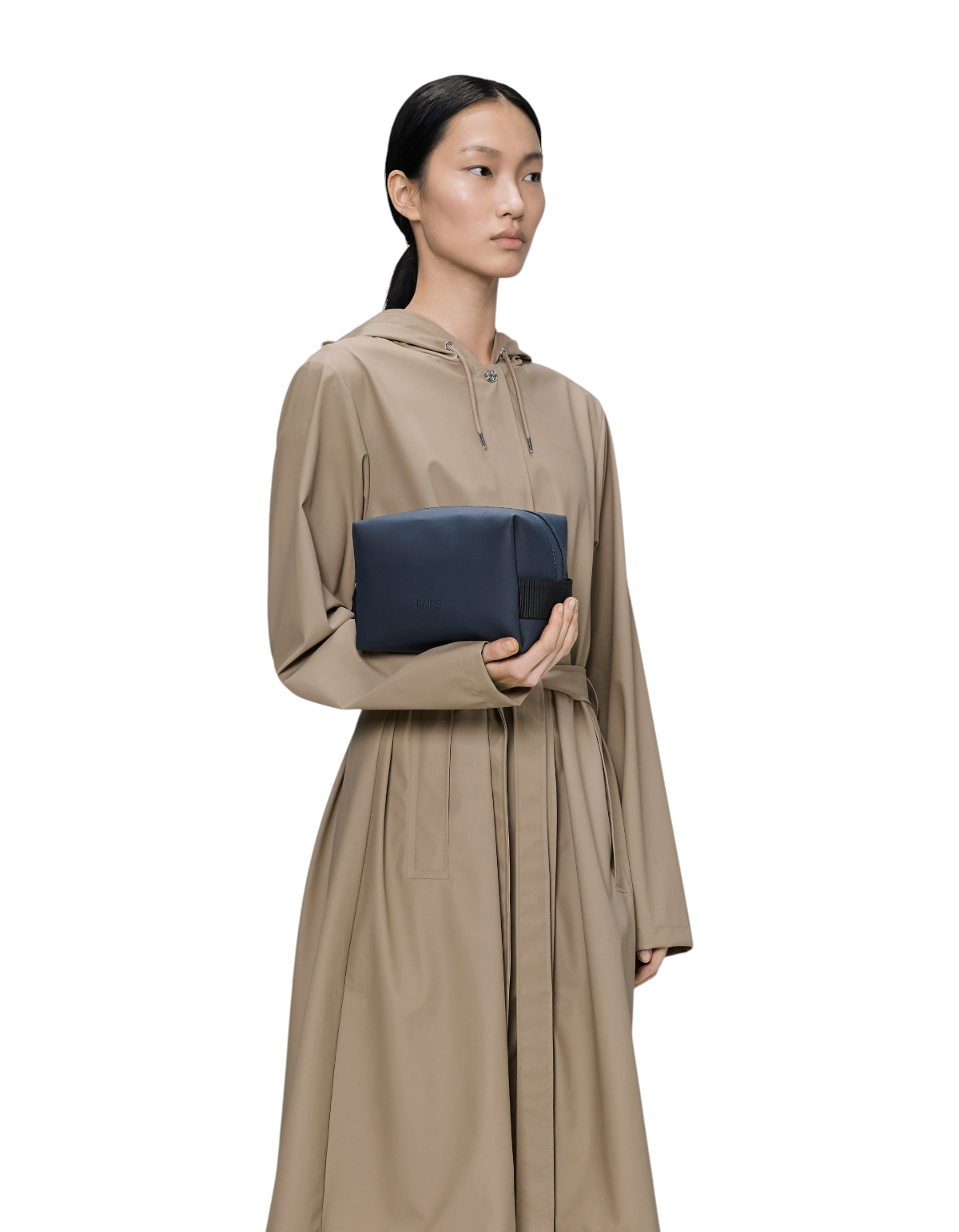 Modella che tiene la borsa da toilette DevidLabel Rains Wash Bag Small blu navy in tessuto impermeabile