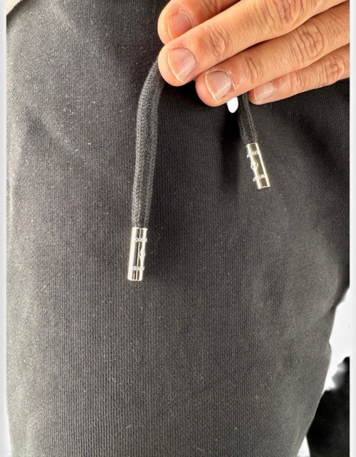 Dettaglio dei lacci neri con puntali in metallo logati del pantalone in cotone DevidLabel Marcelo Burlon County Of Milan