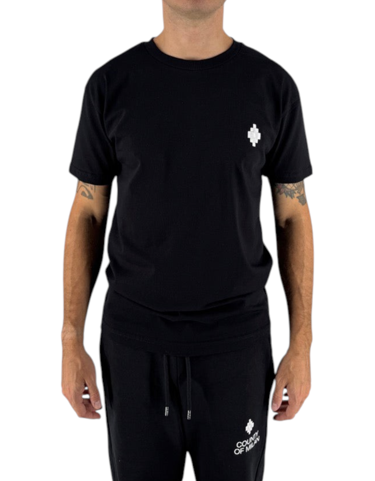 Modello indossa t-shirt nera in cotone Marcelo Burlon County Of Milan con logo bianco, disponibile su DevidLabel