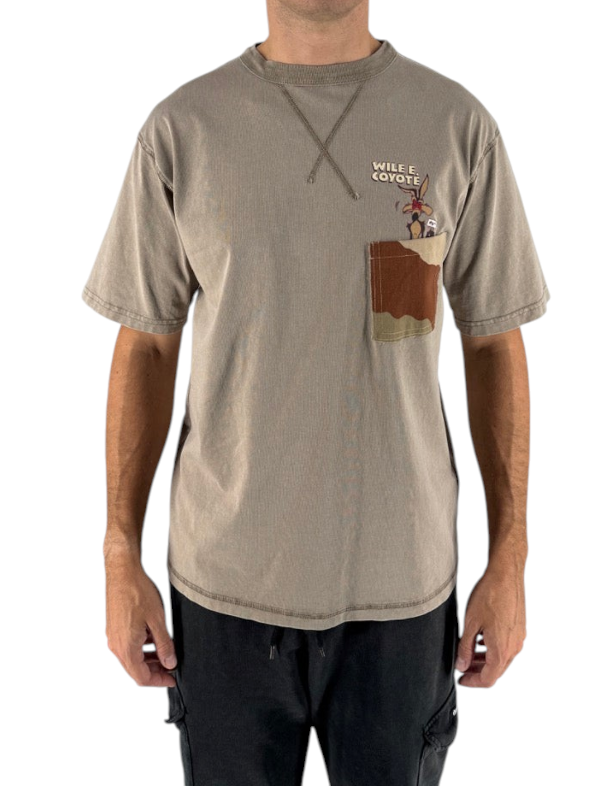 Modello indossa t-shirt DevidLabel color verde agave con taschino, stampa Wile E. Coyote e dettaglio cucitura a X