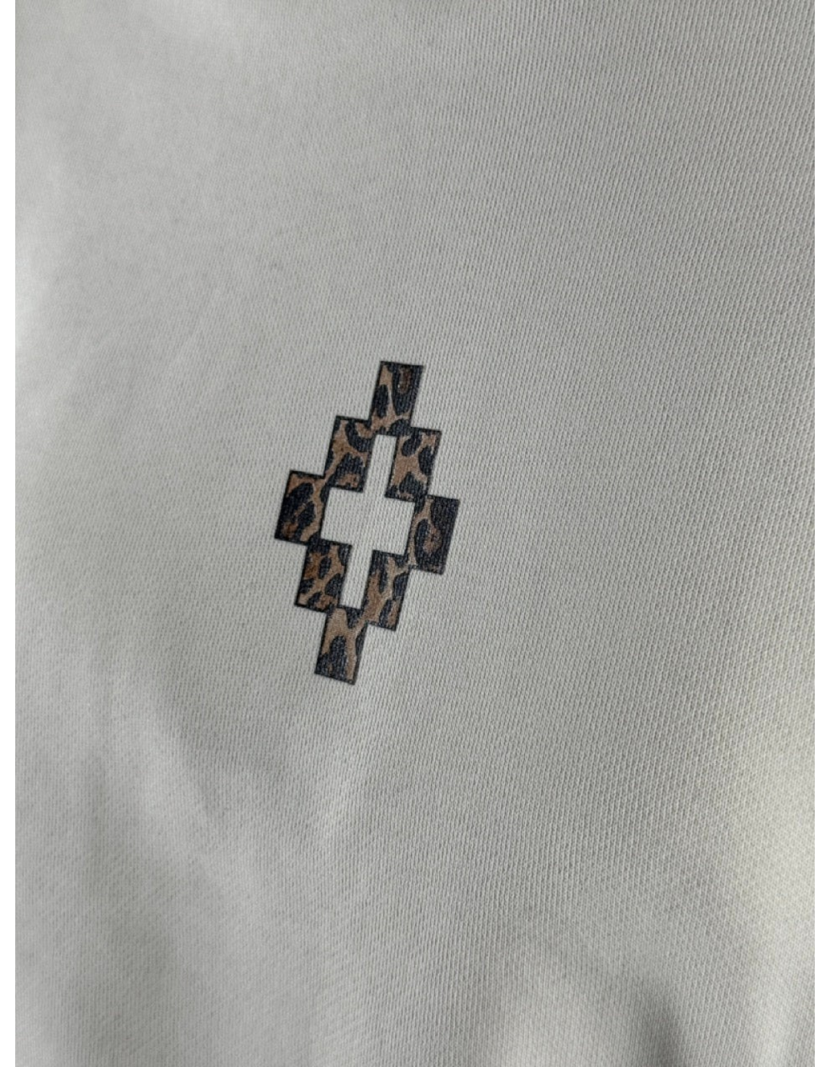 Dettaglio del logo a croce animalier su felpa color latte DevidLabel Marcelo Burlon County Of Milan