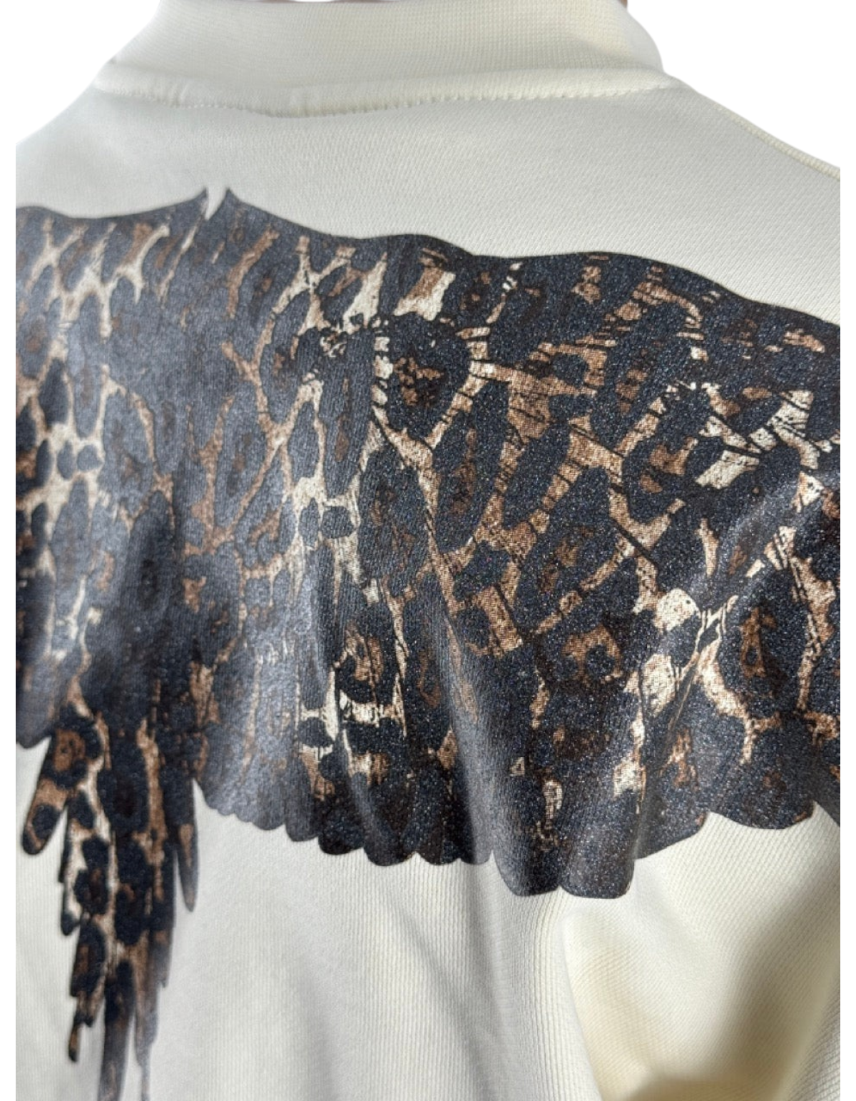 Dettaglio della felpa DevidLabel Marcelo Burlon - County Of Milan color latte con stampa grafica animalier scura