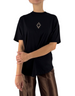 Modella indossa maglia nera in jersey Marcelo Burlon - County Of Milan con taglio corto e logo sul petto