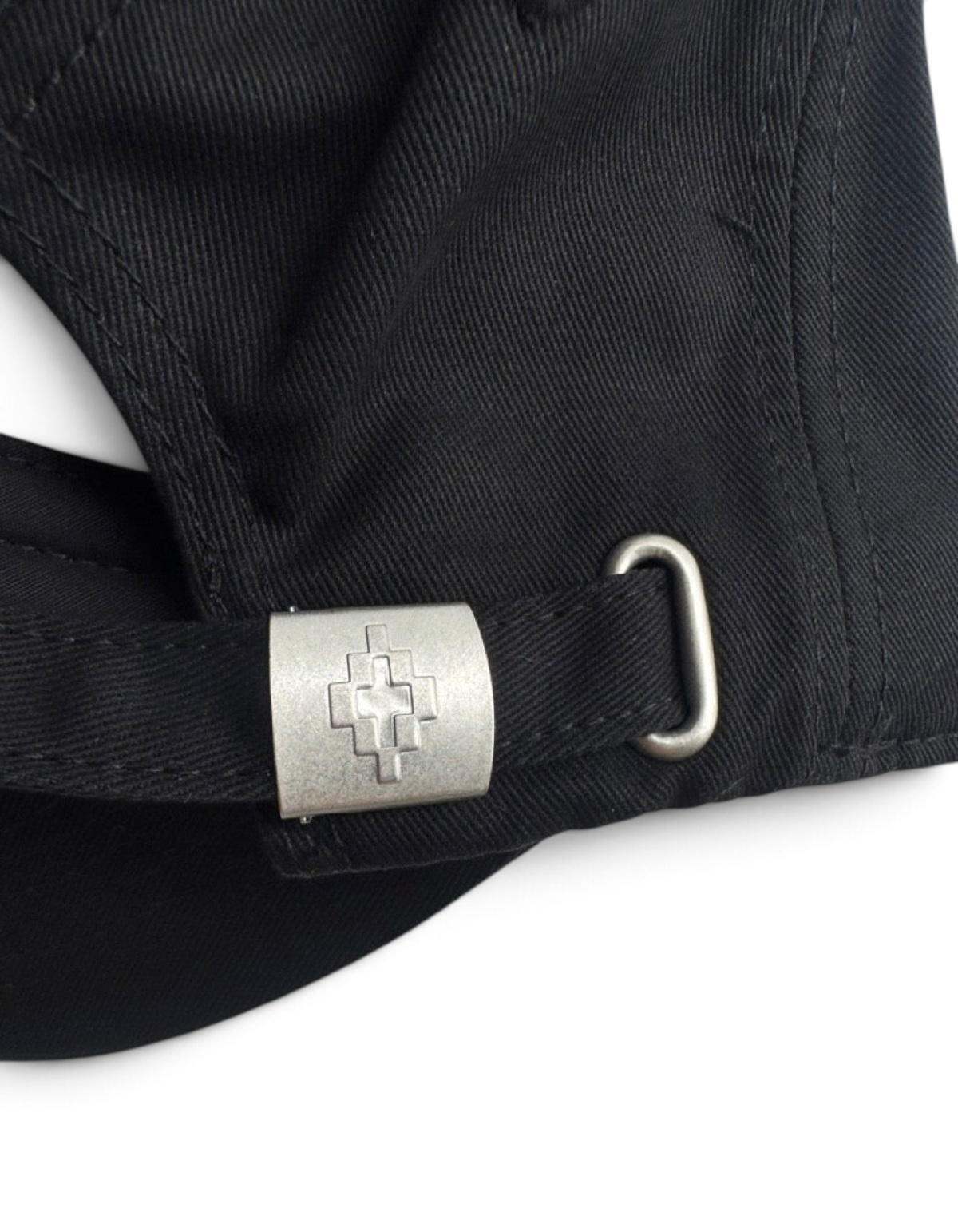 Dettaglio della fibbia metallica con logo su cappellino baseball nero in cotone DevidLabel