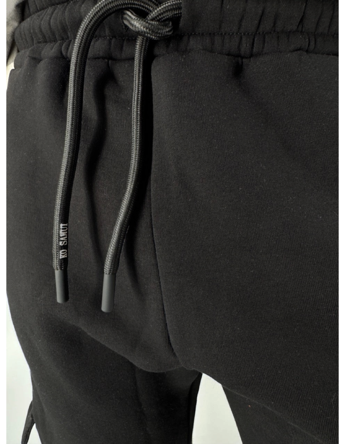 Dettaglio dei pantaloni felpa neri Ko Samui in misto cotone con coulisse regolabile e logo Ko Samui