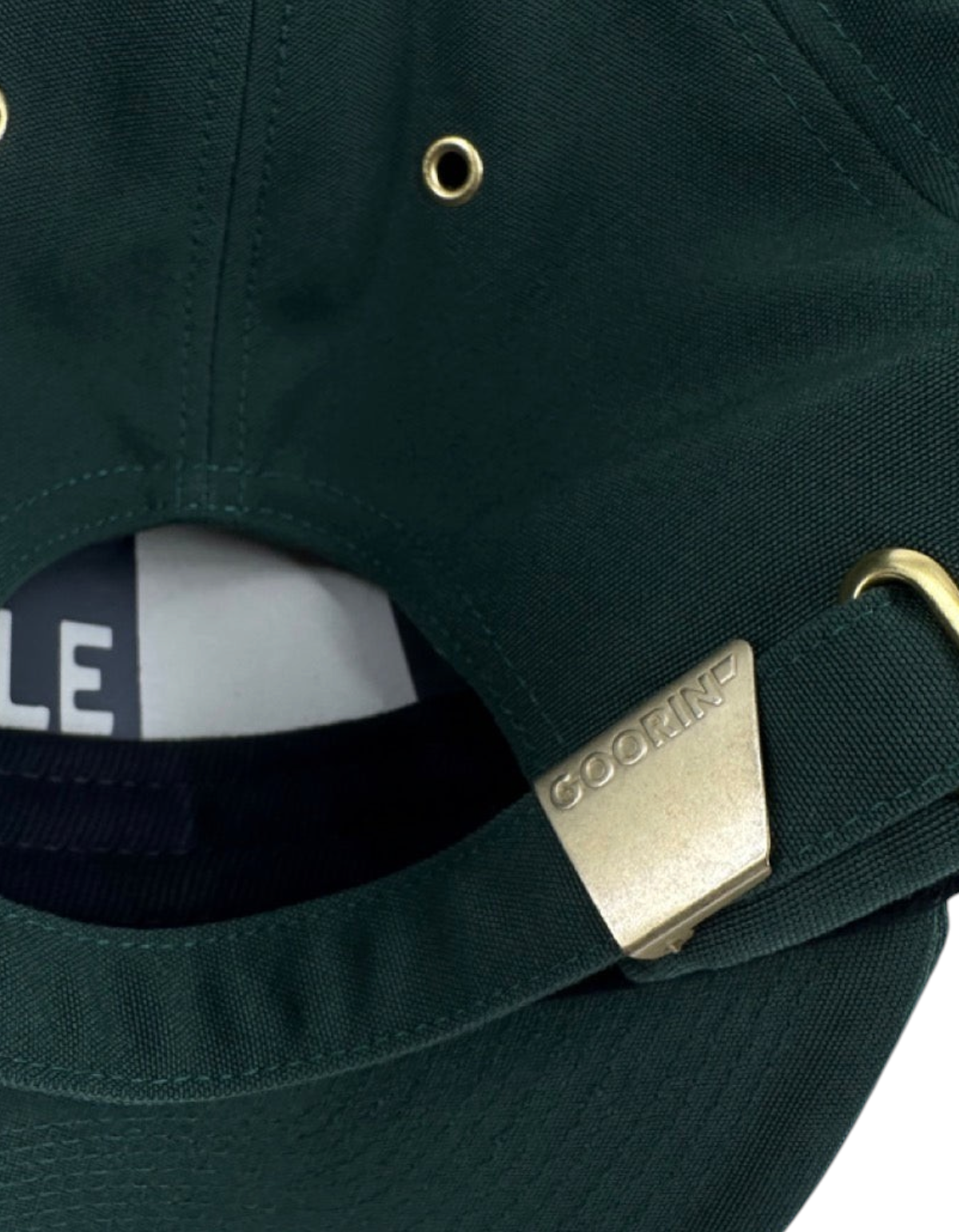 Dettaglio della chiusura posteriore in metallo dorato del cappellino DevidLabel Goorin Bros in cotone verde scuro