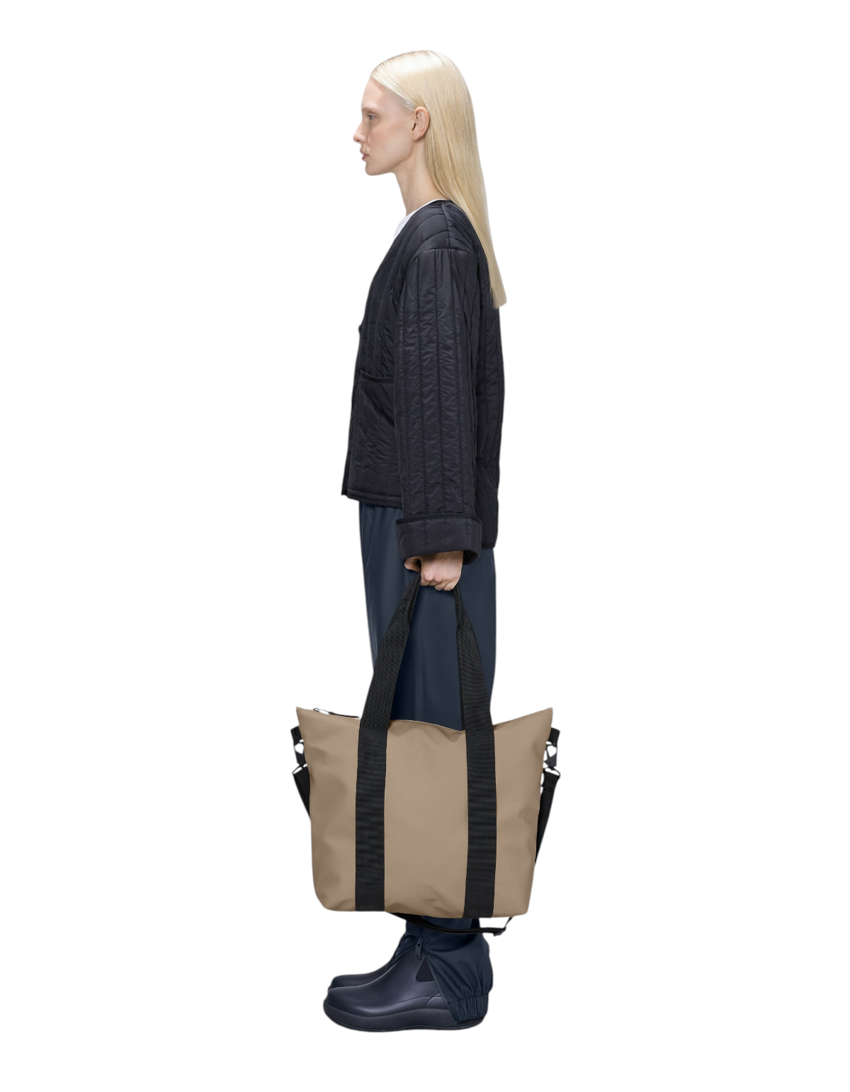 Modella di profilo indossa la borsa DevidLabel Rains Tote Bag Mini beige impermeabile con manici neri e tracolla