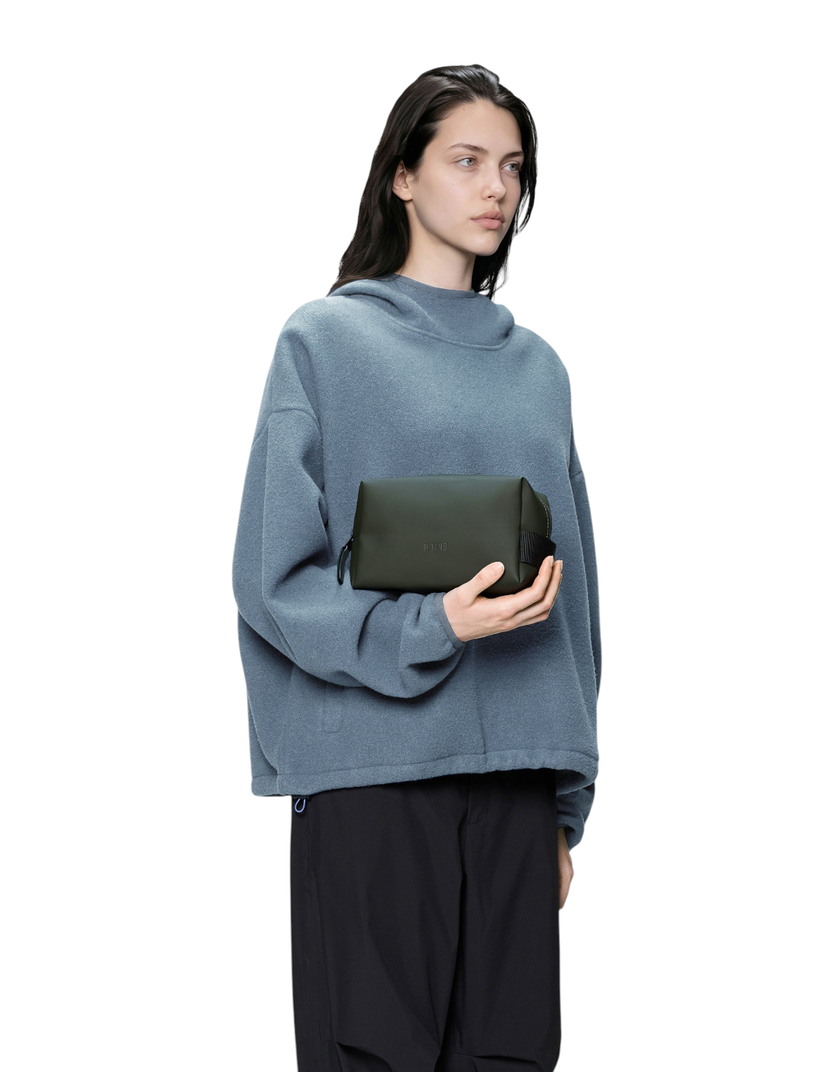 Modella che tiene in mano la borsa da toilette Rains Wash Bag Small verde in tessuto impermeabile