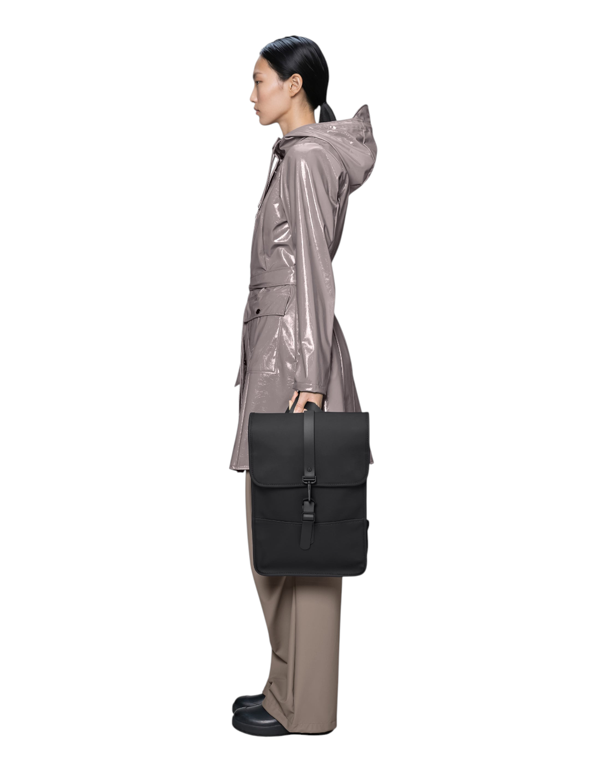 Modella di profilo con zaino nero DevidLabel Rains Backpack Mini impermeabile in tessuto PU, design minimalista